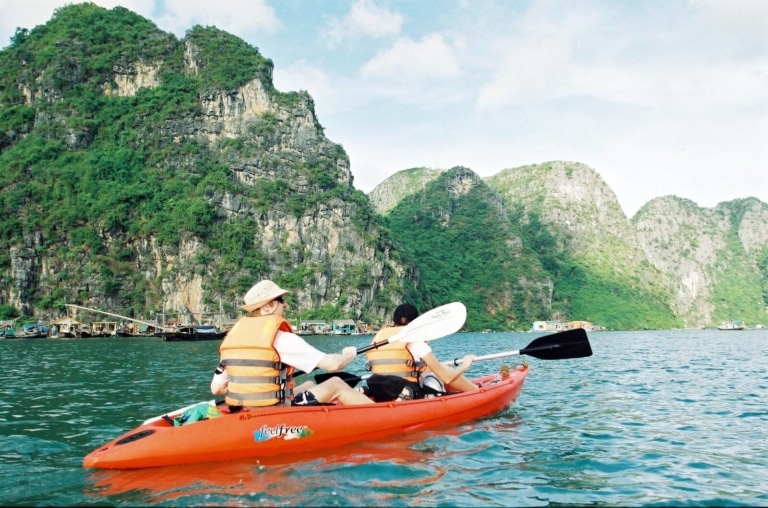 couple-kayaking-ha-long-bay-floating-fishing-village